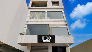 A hotel building with a sign reading 'HOTELO' and a company-serviced logo.