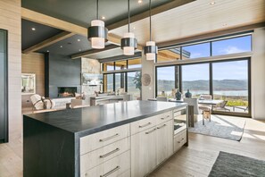 Cocina moderna con una isla grande, electrodomésticos integrados y vistas al exterior.
