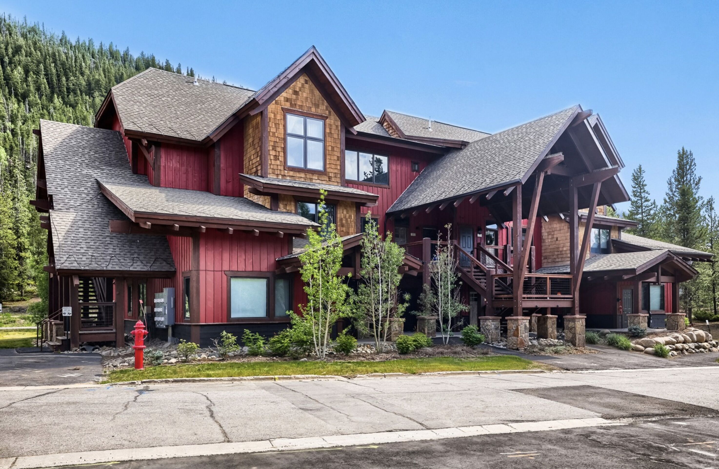 A multi-story wooden lodge with a prominent staircase and a fire hydrant in the foreground.