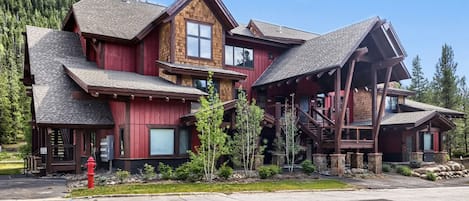 A multi-story wooden lodge with a prominent staircase and a fire hydrant in the foreground.