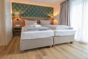Ein Doppelbett mit Kopfteil, zwei Nachttische und eine Wand mit geometrischem Muster.