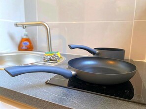 A kitchen with a stove, a pan, and a bottle of dish soap. - A Cozy Retreat 150 Meters from the Arènes - Comfort - Restaurant (Nîmes)