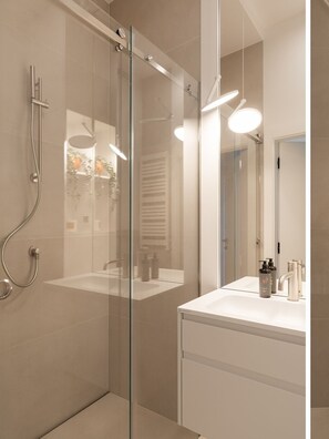 A modern bathroom with a glass-enclosed shower, a white sink, and a mirror. - Bulvar Penthouse Collection Gdańsk (Gdańsk)