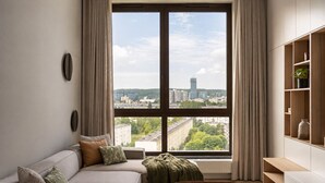 Ein modernes Wohnzimmer mit großem Fenster, einer Couch, einem Couchtisch und einer Einbauschrankschrank.