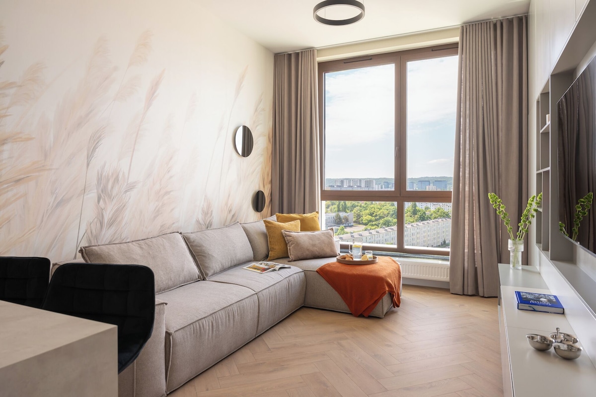 A modern living room with a sectional sofa, a dining table, and a large window with a city view.