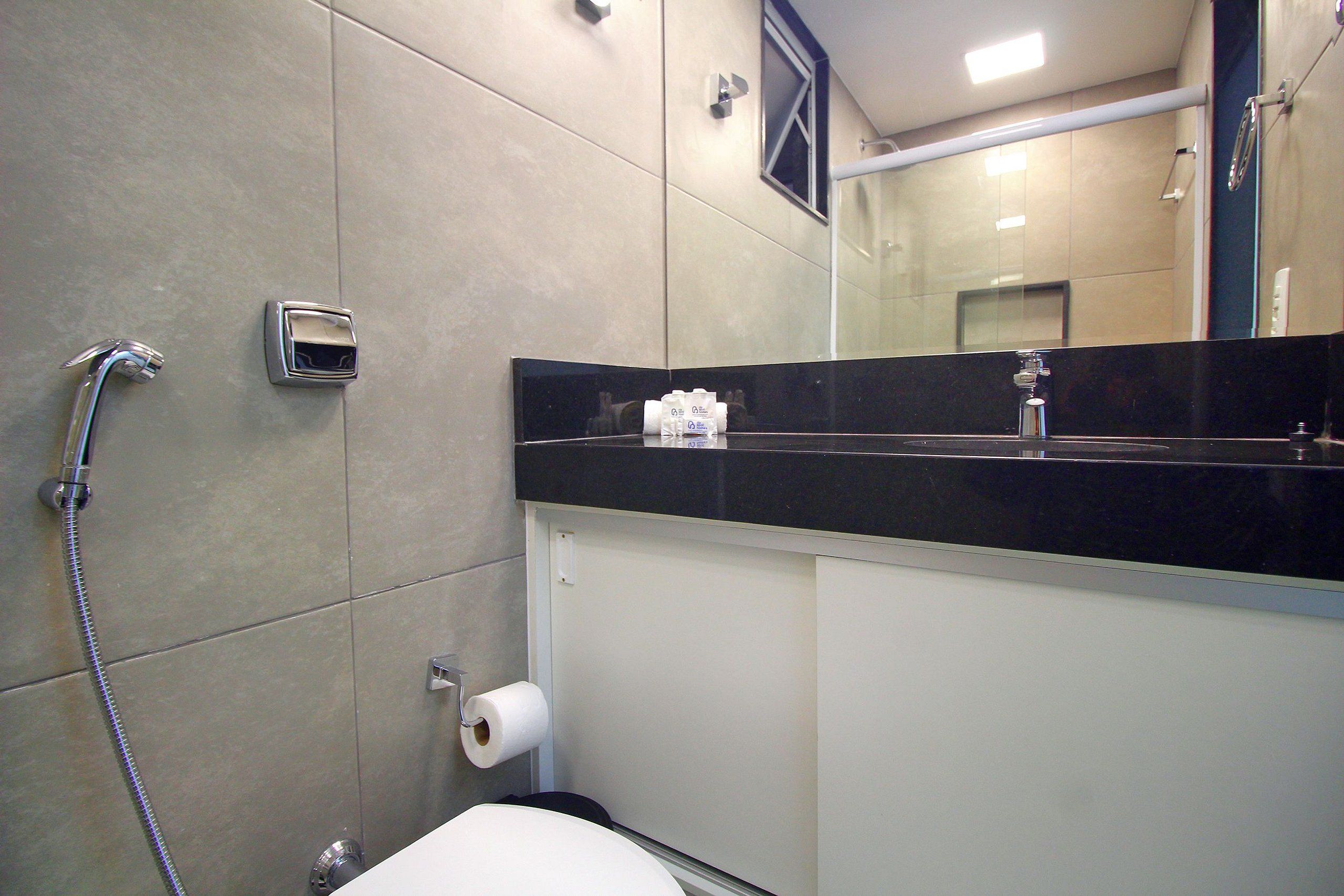 A bathroom with a shower, toilet, and a mirror.