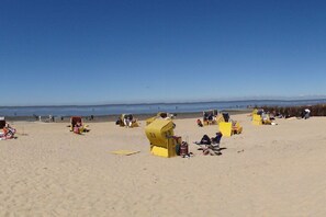A beach with yellow lifeguard towers and beach chairs. - Holiday apartment Maike Duhnen (Cuxhaven - Duhnen)