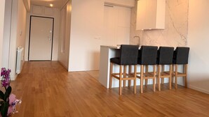 Een moderne keuken met een marmeren spatwand, houten stoelen en een inbouw kookeiland.