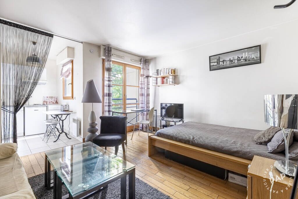 A compact room with a bed, a glass table, a chair, a desk, and a TV.