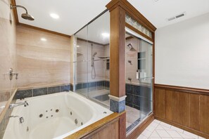 Une salle de bain équipée d’une baignoire, d’un espace douche et d’un meuble-lavabo.