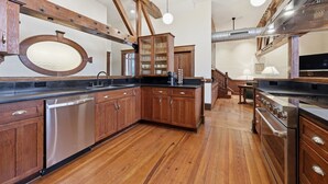 A kitchen with wooden cabinets, a stainless steel dishwasher, and a built-in oven.