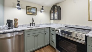 A modern kitchen with a built-in oven, a sink, and a coffee machine.