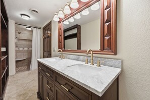 Une salle de bain avec un double lavabo, un meuble-lavabo et un grand miroir.