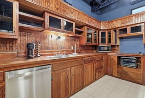 Une cuisine dotée de meubles en bois, d’un lave-vaisselle en acier inoxydable, d’un four à micro-ondes et d’un four grille-pain.