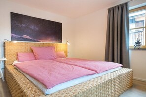 A bedroom with a bed, a night sky poster, a window with curtains, and a bedside lamp. - Holiday apartment in Oberstdorf with sauna (Oberstdorf)