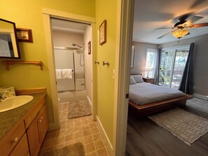 Een badkamer met een wastafel, spiegel en douche.