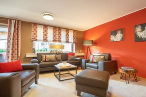 A living room with a sofa, armchairs, a coffee table, and a lamp. - Holiday apartment with 2 bedrooms (Oberstdorf)