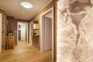 A hallway with wooden flooring, a mirror, and a door. - Holiday apartment with 2 bedrooms (Oberstdorf)