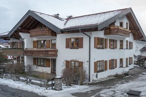 A two-story building with a sloped roof, wooden balconies, and a white facade. - Holiday apartment with 2 bedrooms (Oberstdorf)
