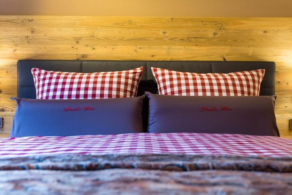 A bed with a checkered bedspread and two pillows with a checkered pattern.