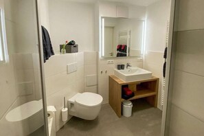 Un bagno moderno con servizi igienici, lavabo e specchio.
