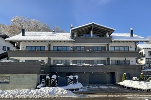 Ein modernes, zweistöckiges Gebäude mit Flachdach, großen Fenstern und einer Garage.