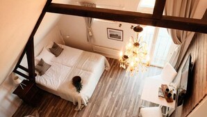 A bedroom with a bed, bedside table, and a chandelier. - Tunnby Gårdshotell (Nyhamnsläge)