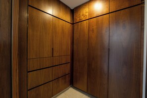 Ein begehbarer Kleiderschrank mit Holztüren und Fliesenboden.