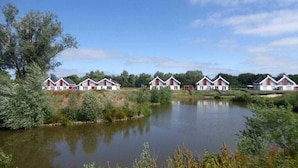 Une rangée de bâtiments rouges et blancs, avec un lac paisible en premier plan.