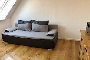 A modern loft bedroom with a built-in bed, wooden flooring, and a window providing natural light. - Studio in the city center (Celle)
