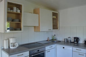 A kitchen with a built-in oven, a coffee maker, and a dishwasher. - Holiday home in Bad Bentheim with Wi-Fi (Bad Bentheim)