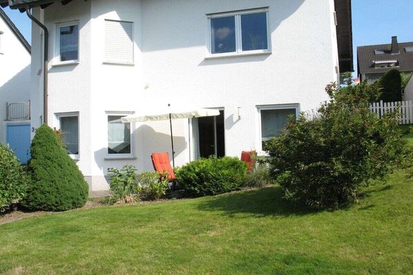 A two-story residential building with a white exterior, a small front yard, and a visible door. - Holiday apartment Rhine-Ahr (Sinzig)