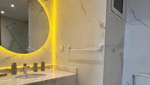 Un bagno moderno con un mobile lavabo in marmo, un portascopevoli in legno e un water.