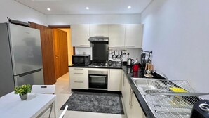 Una cucina moderna con frigorifero, forno a microonde, forno e lavello.