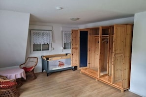 Ein Zimmer mit einem Holfischkasten, einem Korbstuhl, einem kleinen Tisch und einem Aquarium.