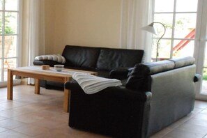 Ein Wohnzimmer mit einer Couch, einem Tisch und einer Lampe.