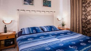 Une chambre à coucher avec un lit, des tables de chevet, une lampe et un rideau.