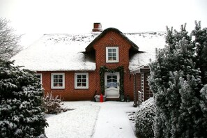 A brick house with a snow-covered roof and a front door. - Holiday home with 4 bedrooms (Risum-Lindholm)