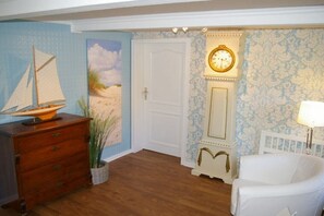 A room with a wooden dresser, a sailboat model, a door, a wall clock, a chair, and a lamp. - Holiday home with 4 bedrooms (Risum-Lindholm)