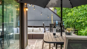 An outdoor patio with a table, chairs, and a large umbrella. - Camelback Home Family Friendly Waterpark Arcade (Tannersville)