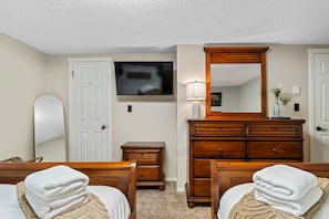 Ein Hotelzimmer mit Bett, Schminktisch, Spiegel, Fernseher und Lampe.