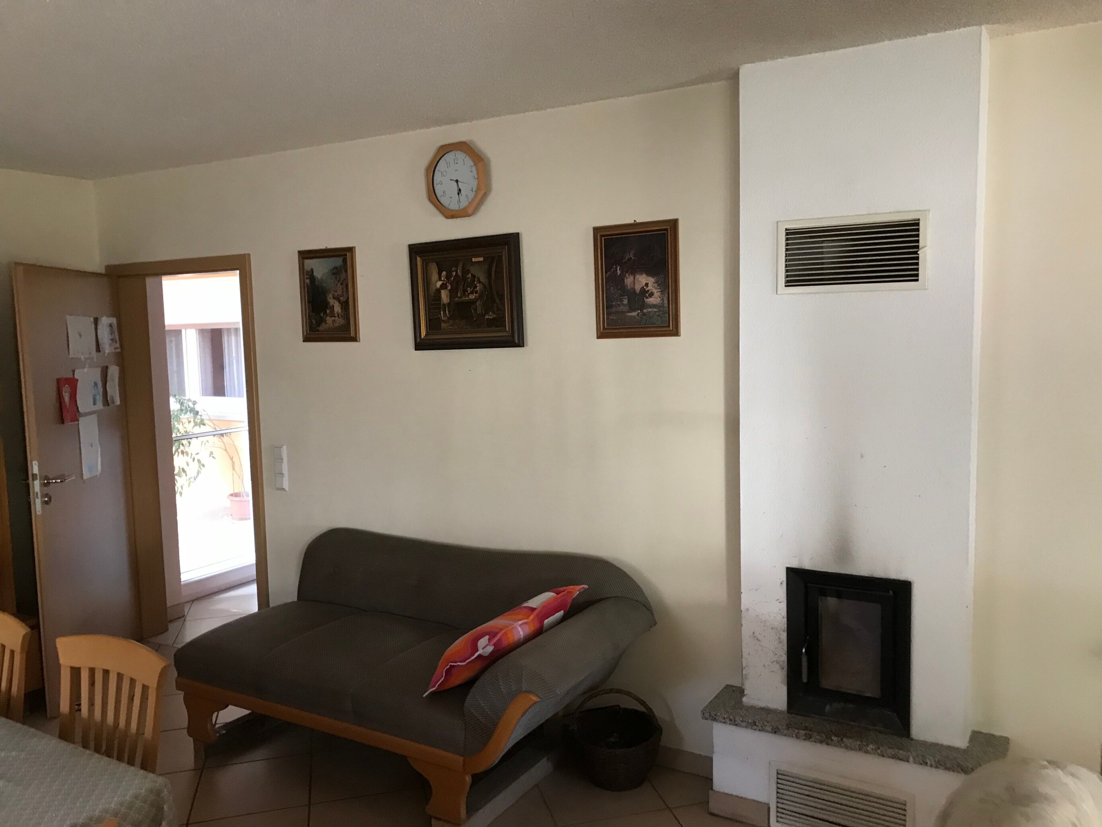 Ein Wohnzimmer mit einer Couch, einem Kamin und an der Wand befestigten Bildern.
