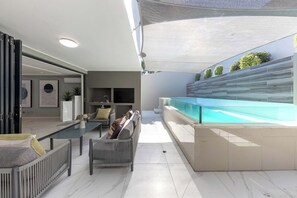 A modern living area with a pool, seating, and a view of the outdoors. - The Blouberg Lookout (Cape Town)