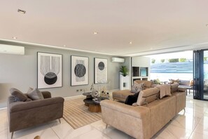 Uma sala de estar moderna com sofá, mesa de centro e obras de arte na parede.