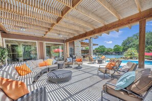 Une terrasse extérieure avec une piscine, un espace salon et une vue sur la piscine.