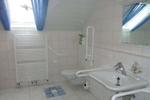 Een badkamer met toilet, wastafel en douche.