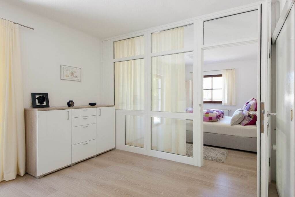Un dormitorio con cama, armario y ventana.