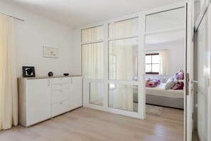 Een slaapkamer met een bed, een kledingkast en een raam.