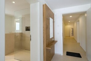 A modern bathroom with a glass shower enclosure, a wooden vanity, and a mirror. - Holiday apartment with 1 bedroom (Überlingen)