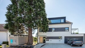 Una moderna casa a due piani con un'auto parcheggiata nel vialetto.